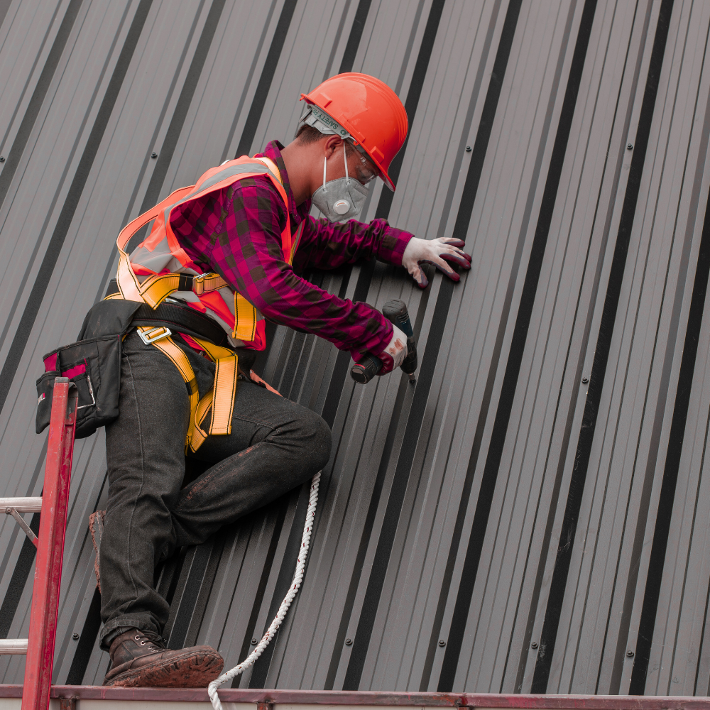 A man working on a metal-sheeted roof